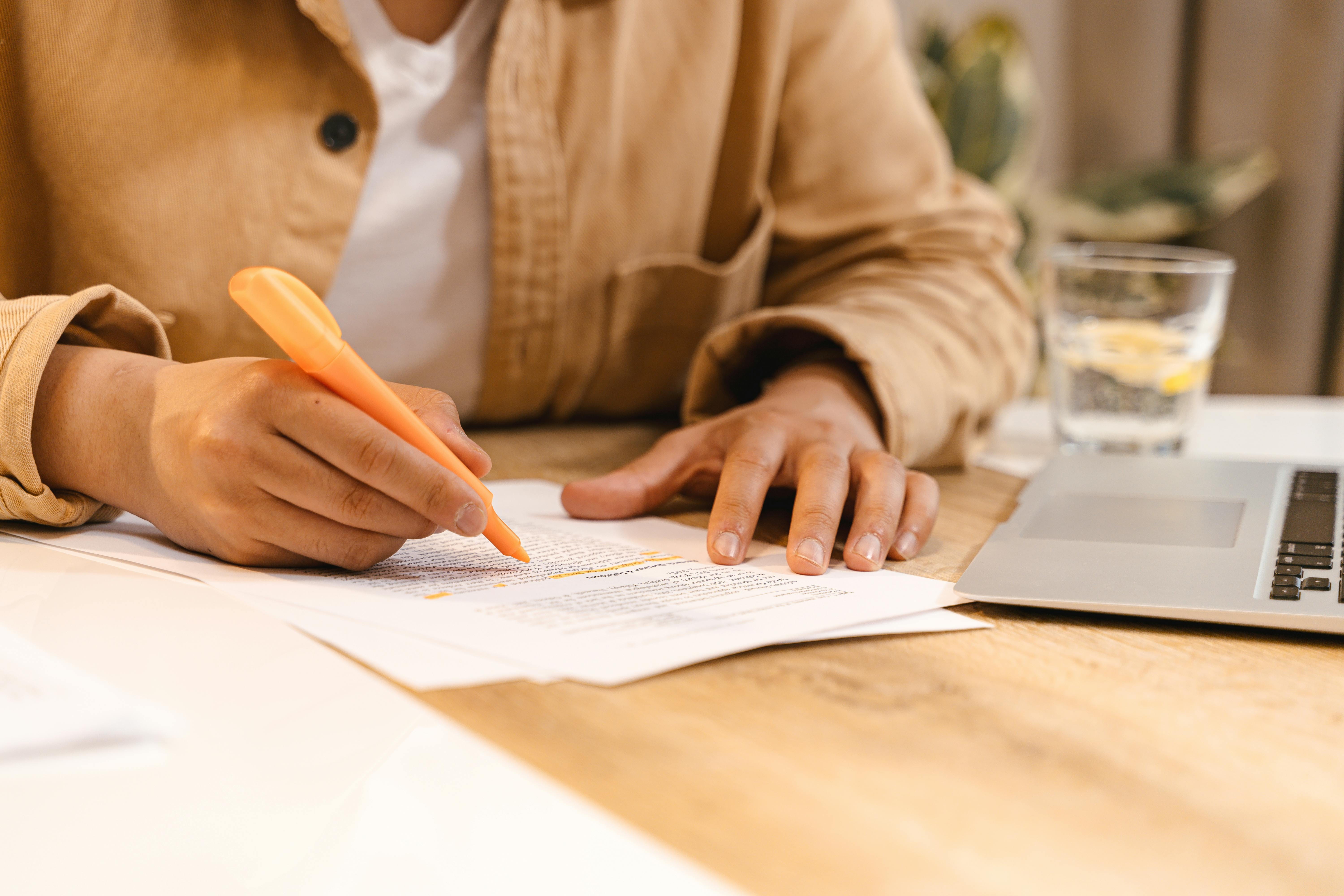 Person's hand highlighting text in a document